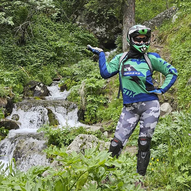 Райдер на Sur-Ron поднимается по серпантину через густой ельник