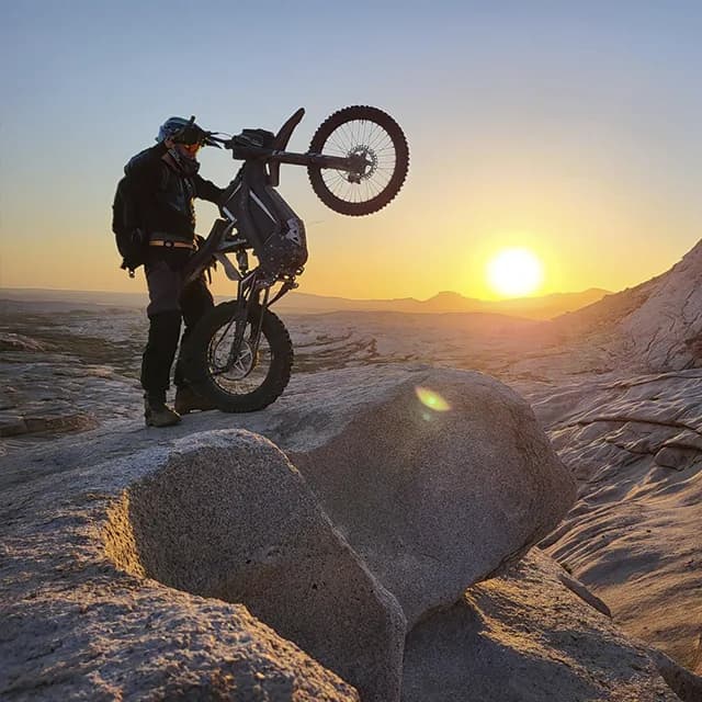 Электробайк заезжает на гладкую гранитную плиту под экстремальным углом