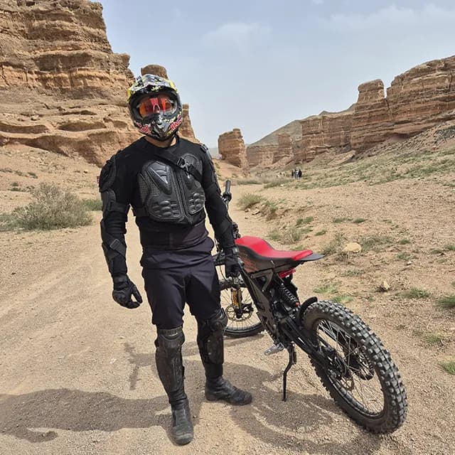 Крутой спуск в Чарынский каньон через слоистые красные скальные формации