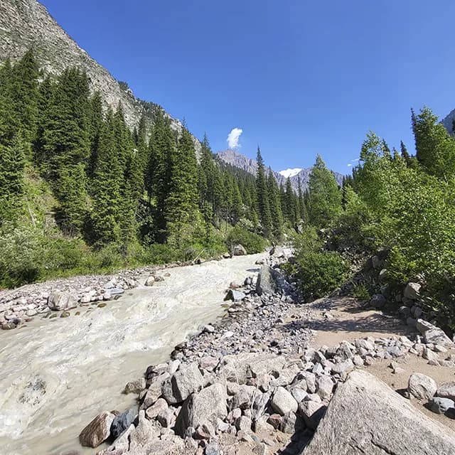 Райдер пересекает бурную горную реку в урочище Левый Талгар