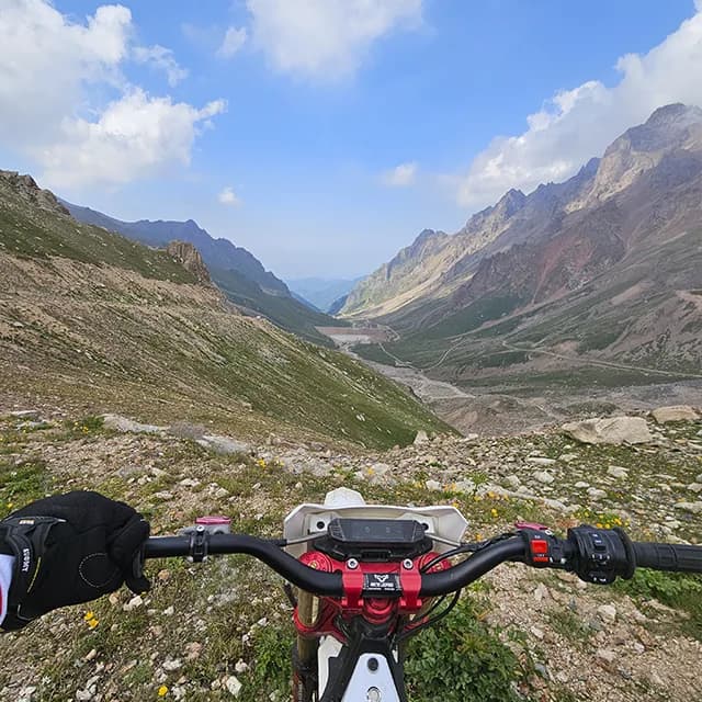 Райдеры лавируют между крупными камнями на дороге выше Шымбулака